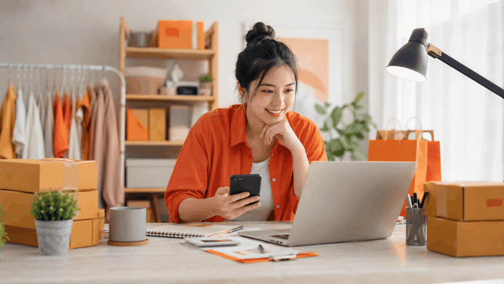 Shopee Affiliate link not tracking guide hero image showing a local creator checking her phone and laptop beside parcel boxes in a home office.