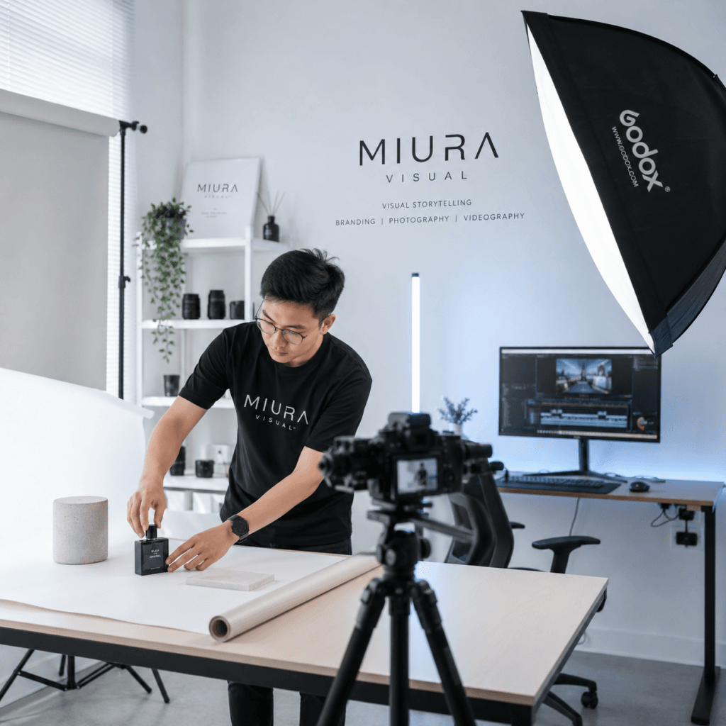 About Miura Visual | Story, Services & Evolution 17 Product photography studio setup at Miura Visual with camera, softbox lighting, backdrop table and editing workspace in Malaysia.